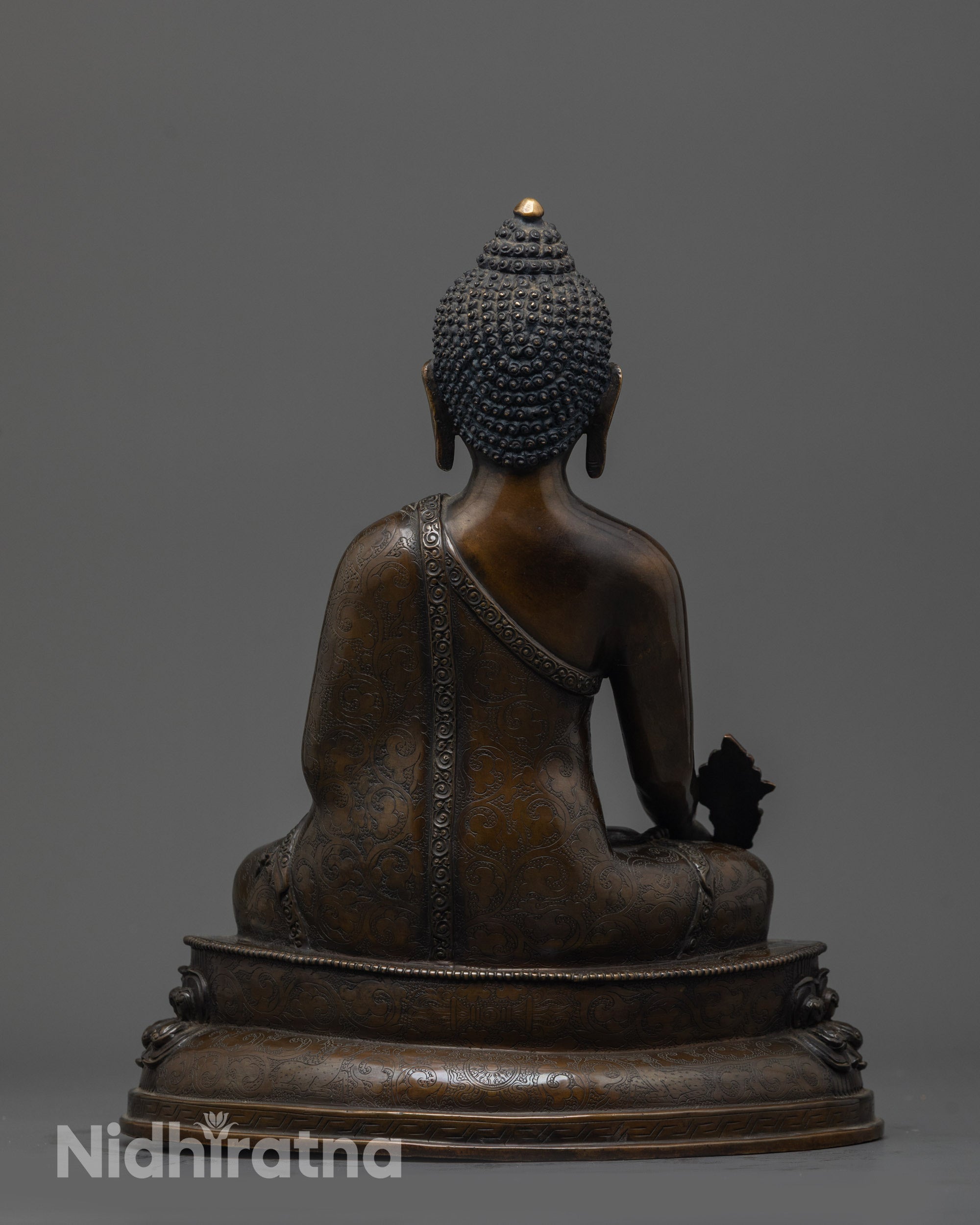 Back view of oxidized Bhaisajyaguru Buddha highlighting monk's robe carvings