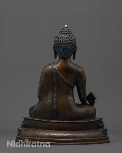 Back view of oxidized Bhaisajyaguru Buddha highlighting monk's robe carvings