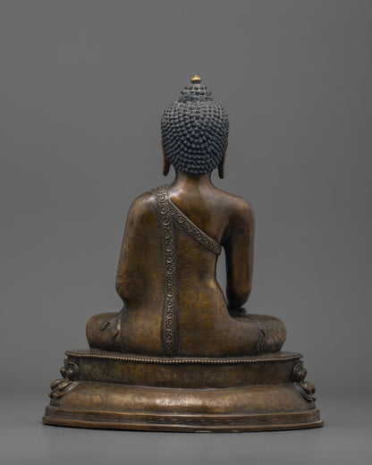 Back view of oxidized Shakyamuni Buddha statue highlighting detailed robe and lotus base