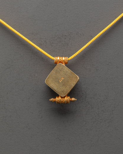 Back view of religious Tibetan pendant featuring traditional Buddhist symbols and ornate design


