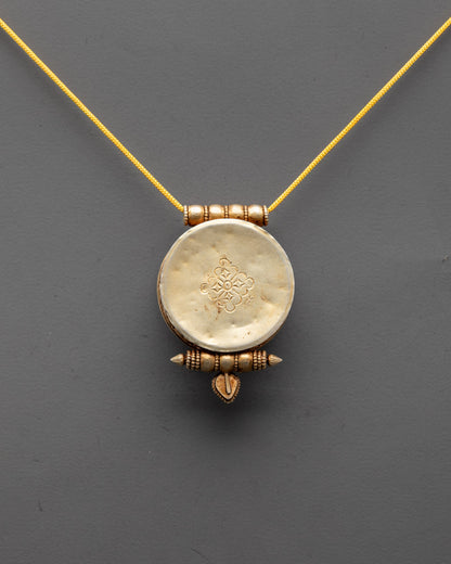 Back view of sacred Tibetan pendant featuring traditional symbols and radiant gold plating


