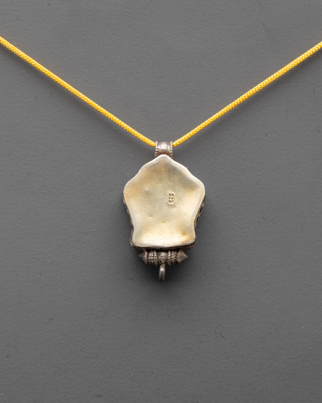 Back view of silver Kalachakra Mantra Pendant showcasing detailed artisan craftsmanship


