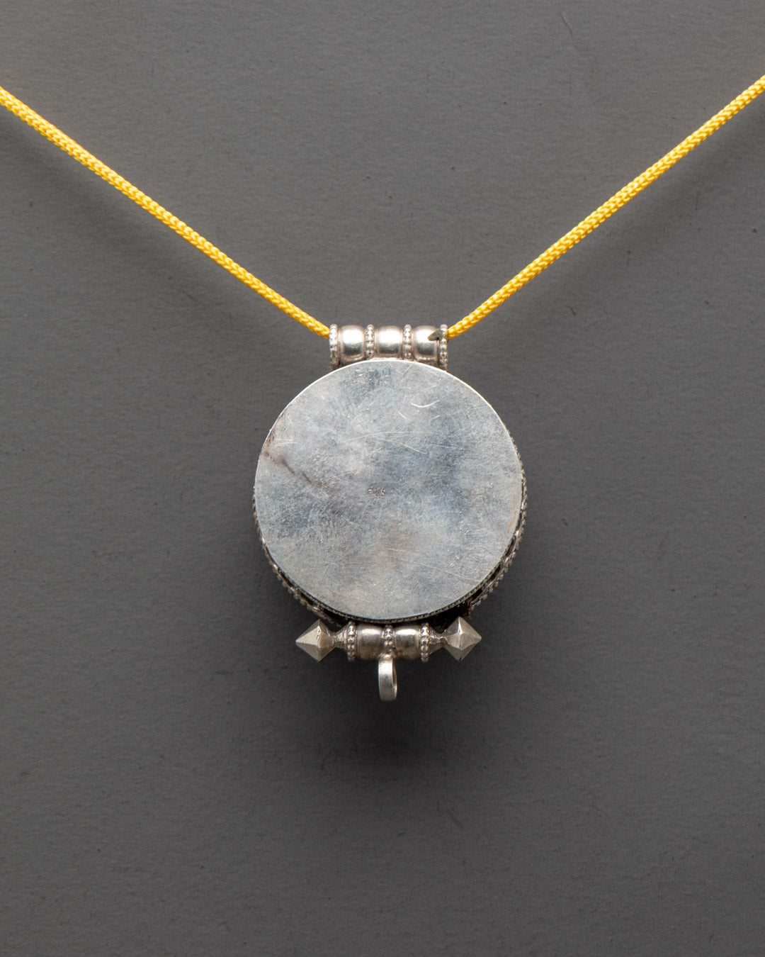Back view of traditional Bishwo Vajra Locket carved by Patan artisans with semi-precious stones