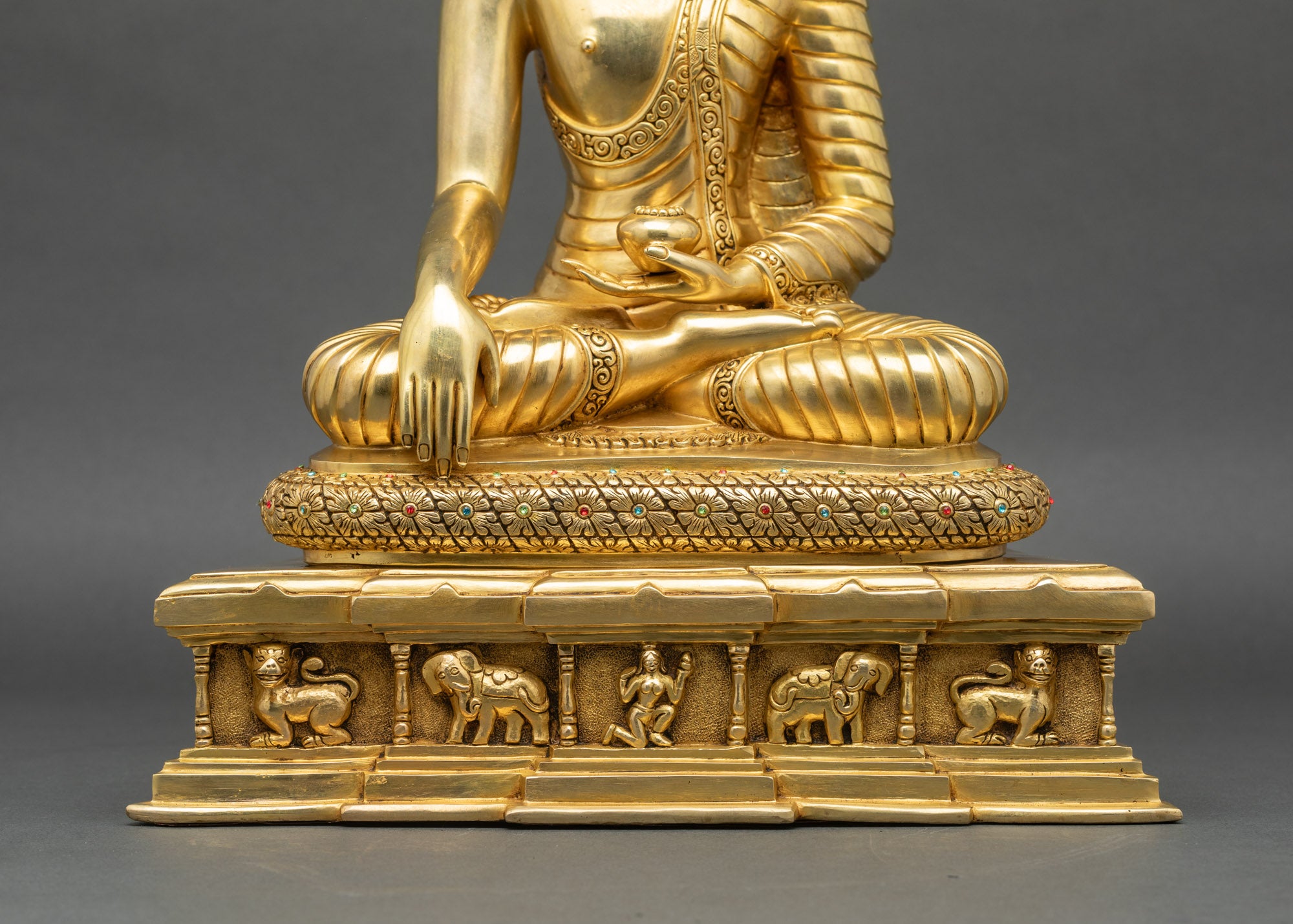 Base view Shakyamuni Buddha statue throne panel carvings elephants lions human figure