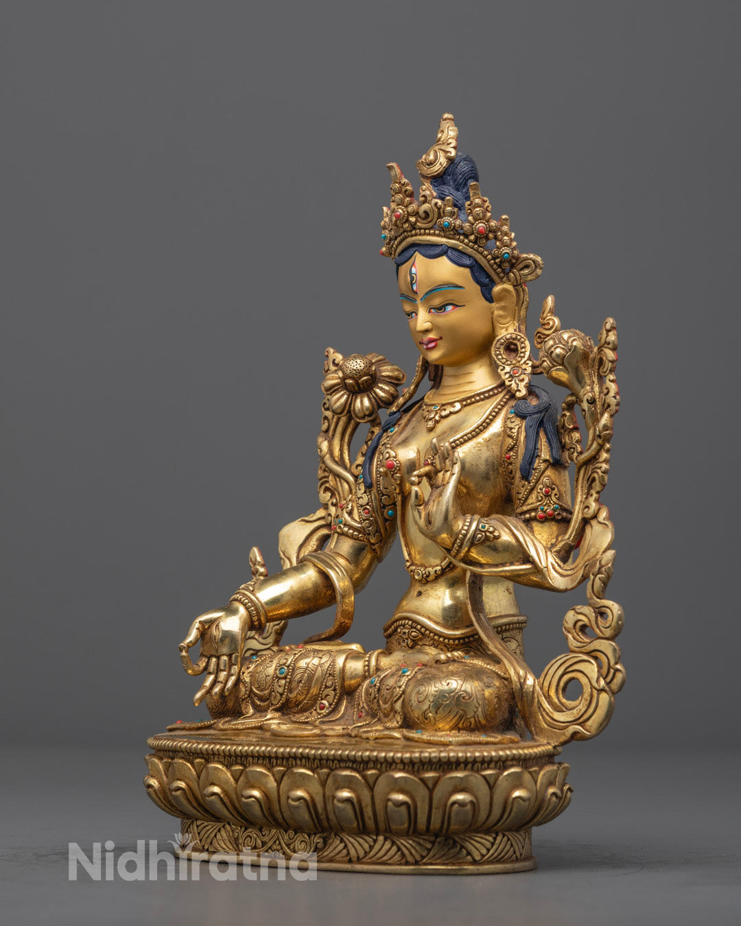 Beautiful Green Tara statue carved from stone, seated in half-lotus posture on a lotus throne, featuring semi-precious stone inlays and a hollow chamber for consecration, handmade in Nepal.