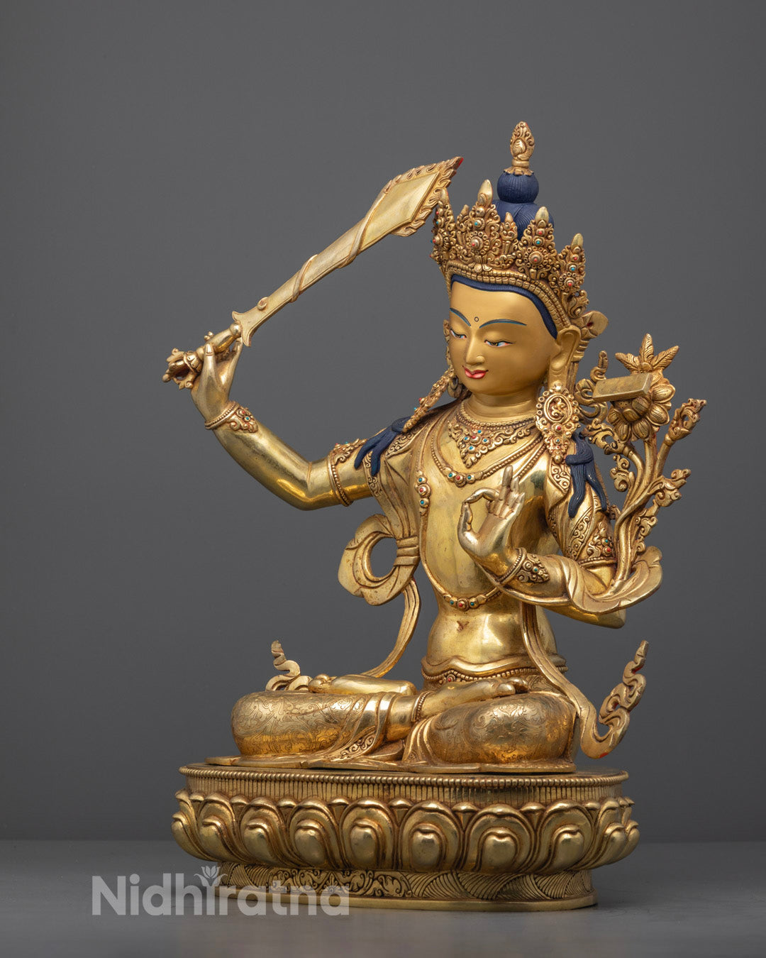 Beautifully detailed Manjushri statue holding a sword and scripture, symbolizing wisdom and compassion in Tibetan Buddhism.