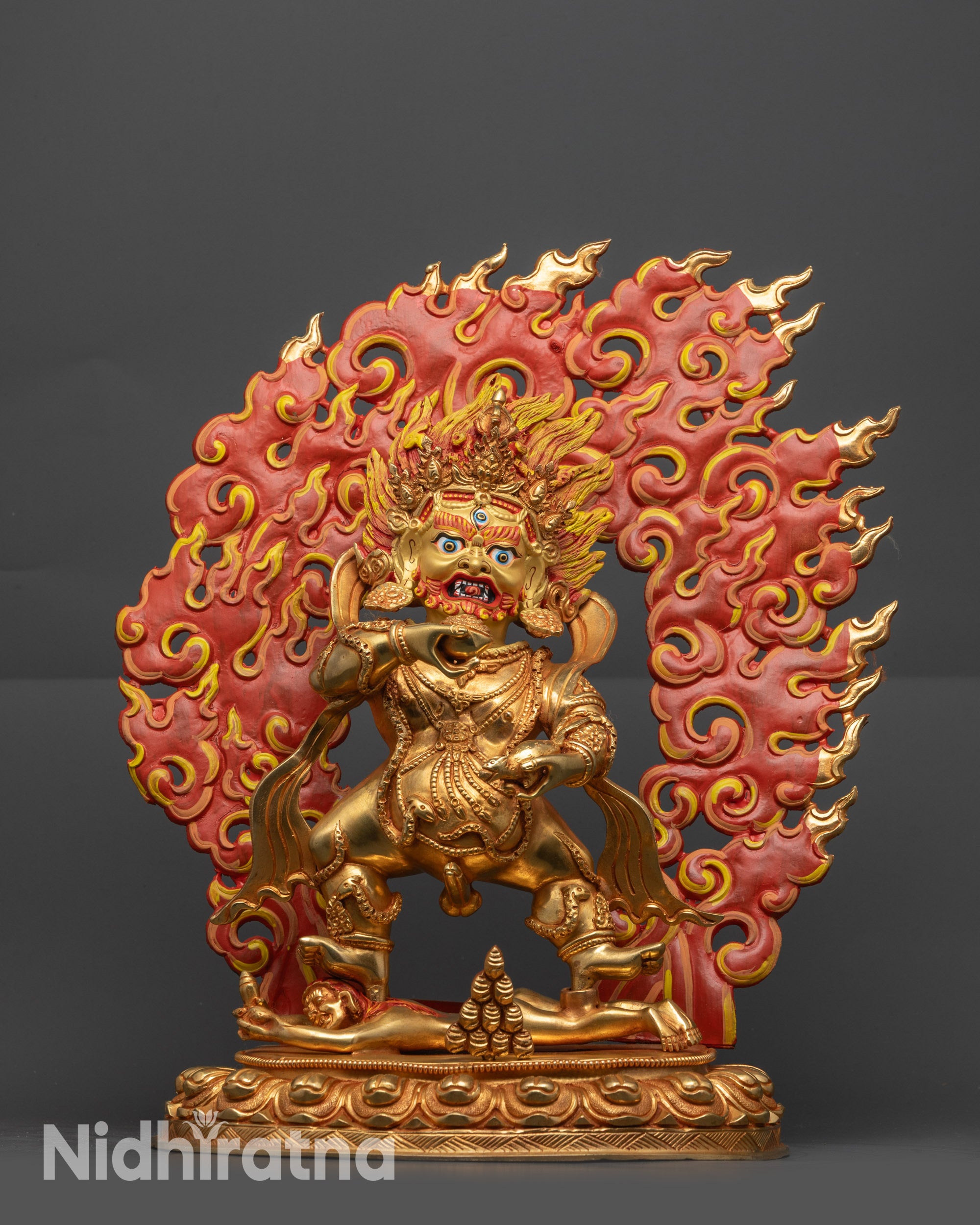 Front View of Fully gold-gilded Black Dzambhala statue with red fire backdrop