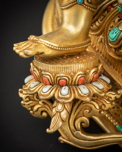 Blue lotus close up under Green Tara Statue on lotus pedestal