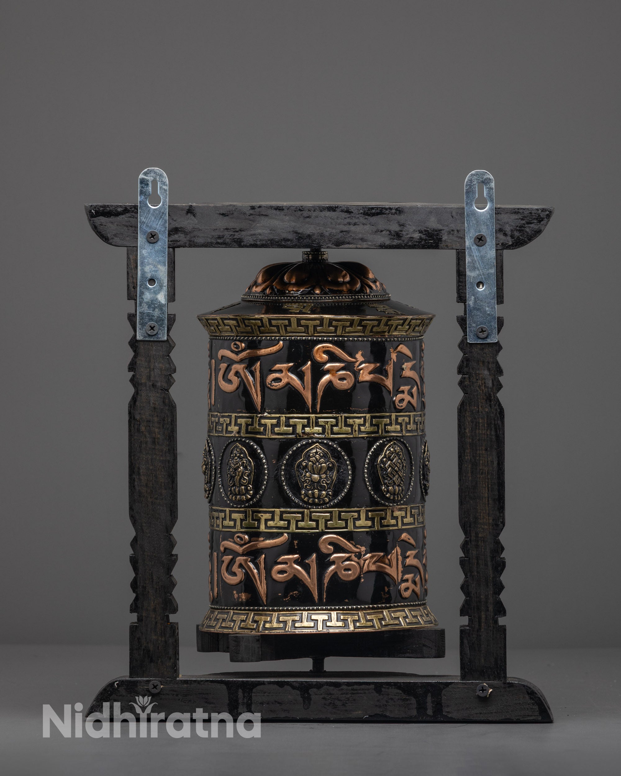 Bronze patterns and white metal symbols on traditional Nepalese prayer wheel for home shrine