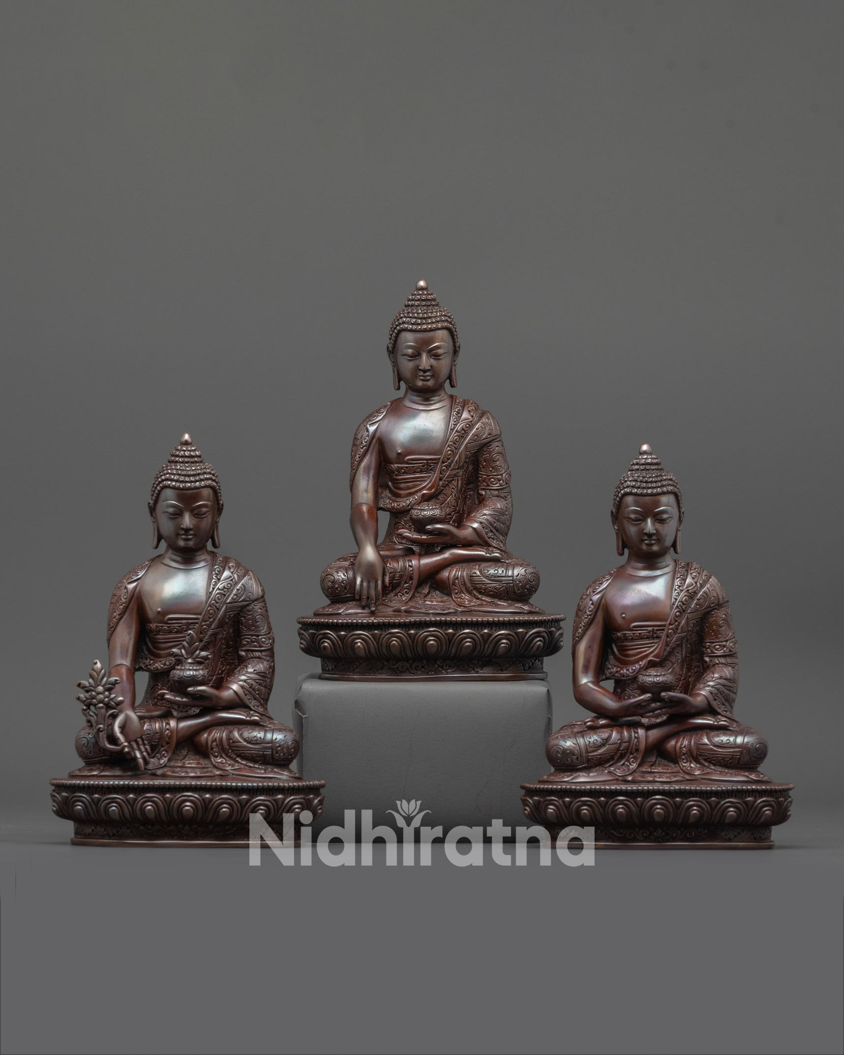 front view of oxidized three buddha set with intricate carved patterns and lotus thrones