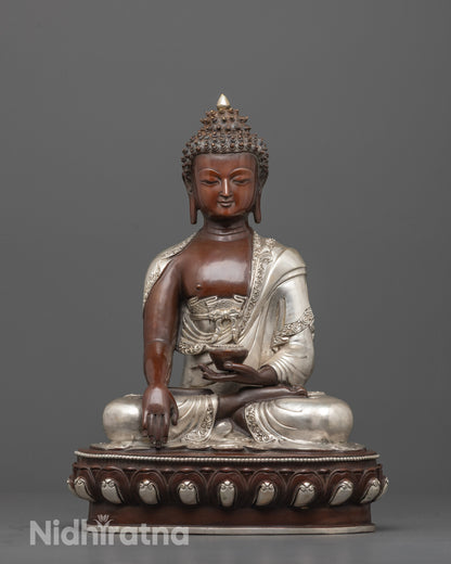 front view of oxidized shakyamuni buddha statue with silver robe and calm expression
