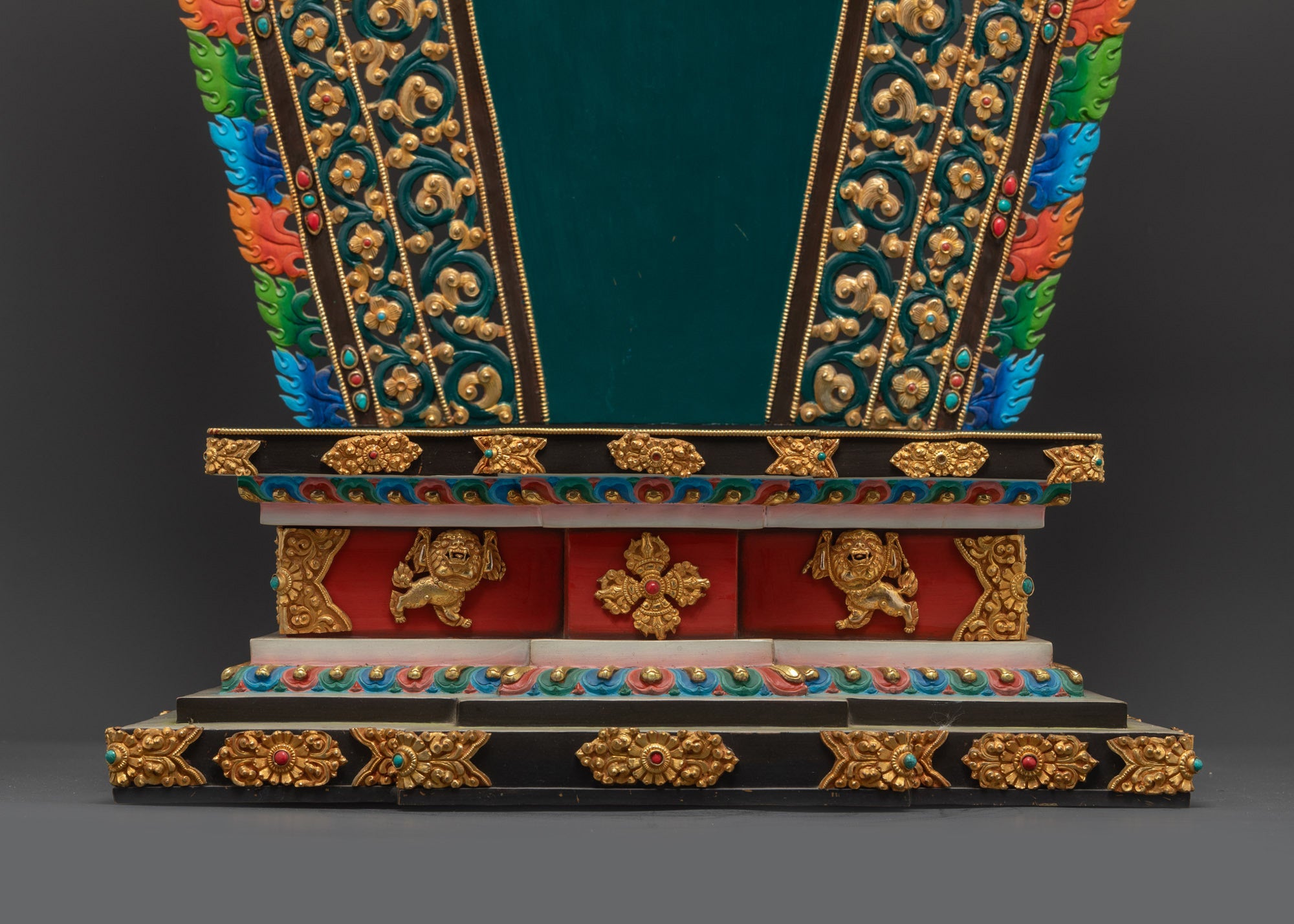 Buddhist statue throne side close up showing lion guardian and gold surface
