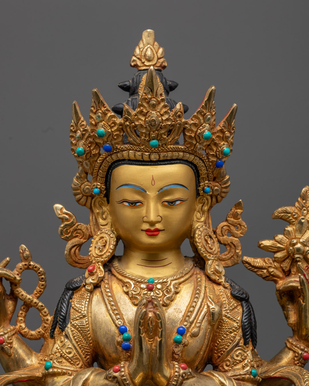 Chenrezig statue holding Akshamala, lotus, and Cintamani – symbols of compassion and spiritual purity