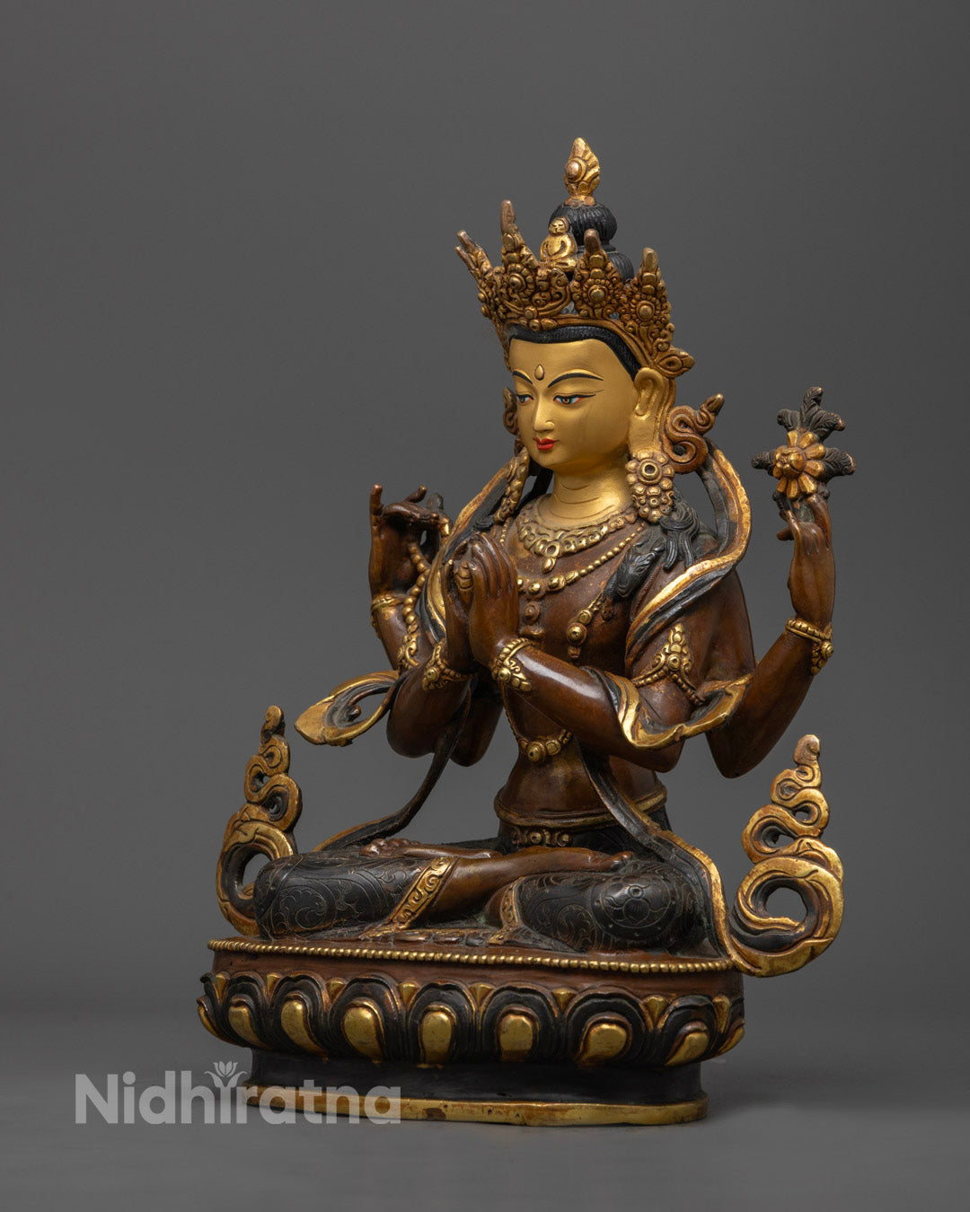 Chenrezig statue holding a mala, utpala flower, and wish-fulfilling gem, representing continuous prayer, purity, and spiritual abundance.