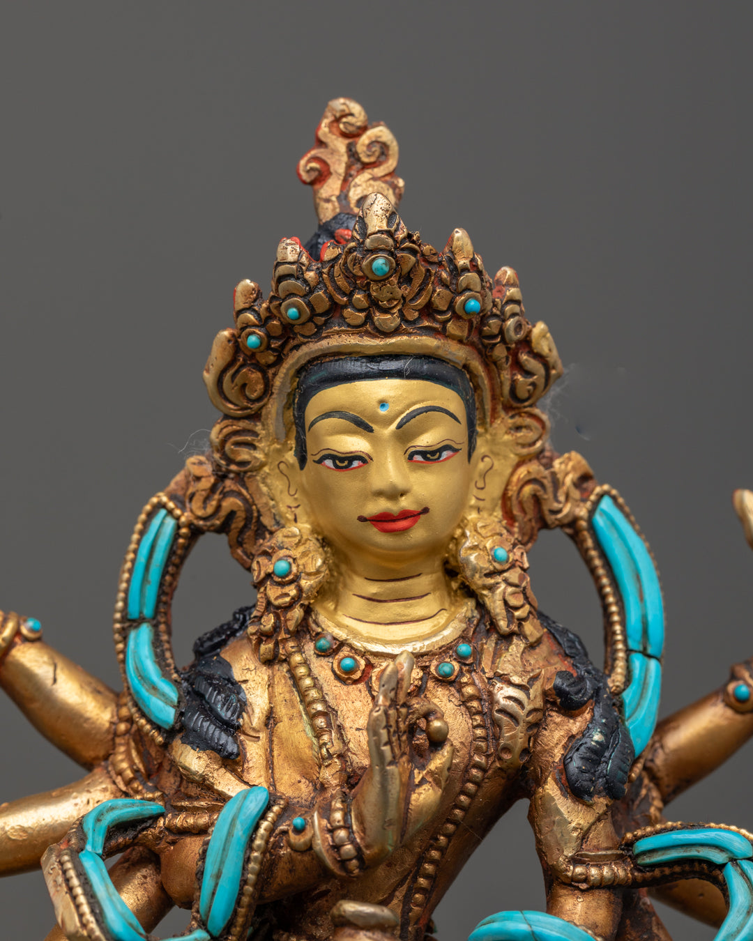 Chenrezig statue’s serene face and intricately carved crown with gold fire-gilding and gemstone inlays, representing the Bodhisattva of Compassion.
