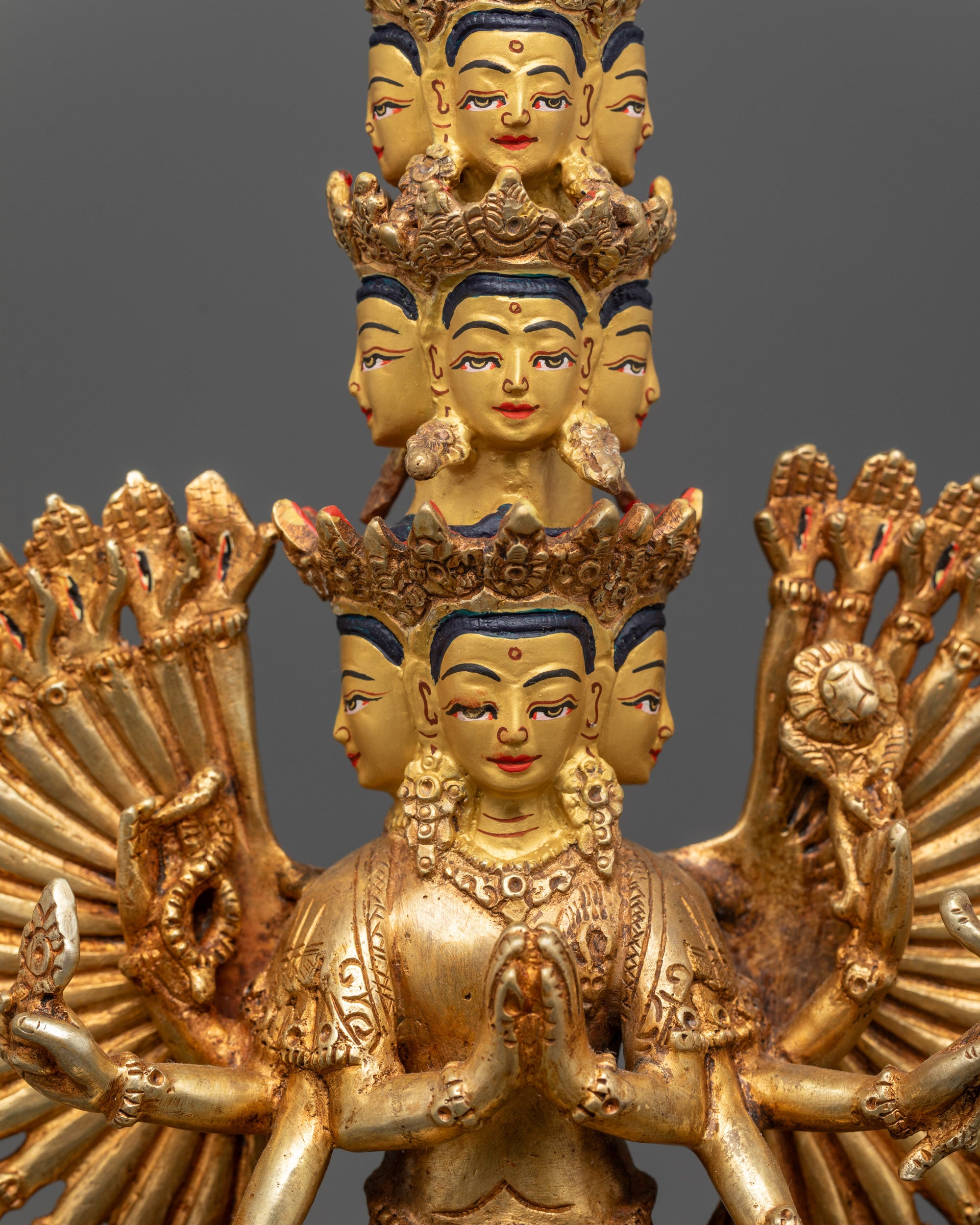 Chenrezig statue showing central hands holding a wish-fulfilling jewel