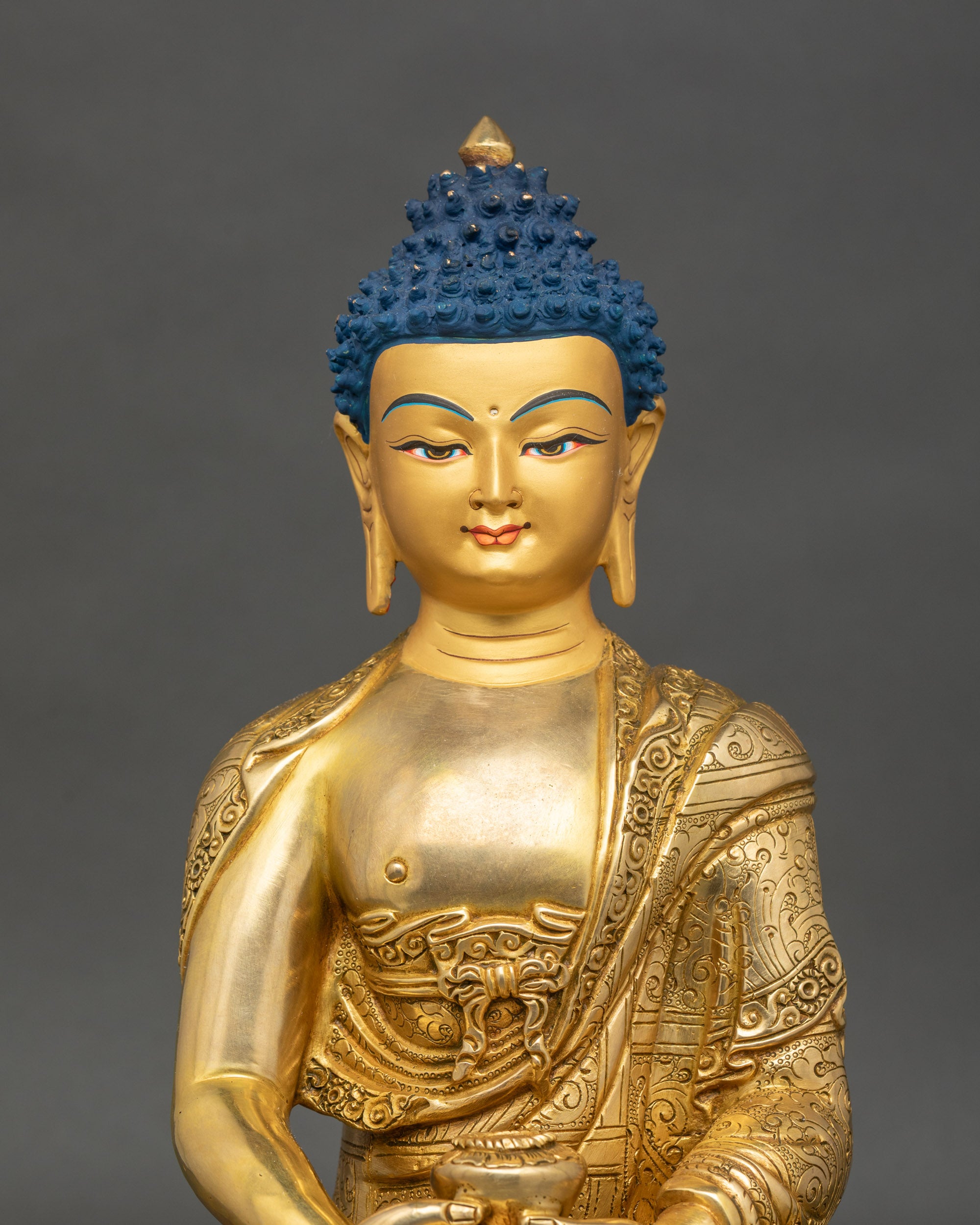 Close-up of Amitabha Buddha statue showing intricate lotus and floral relief details