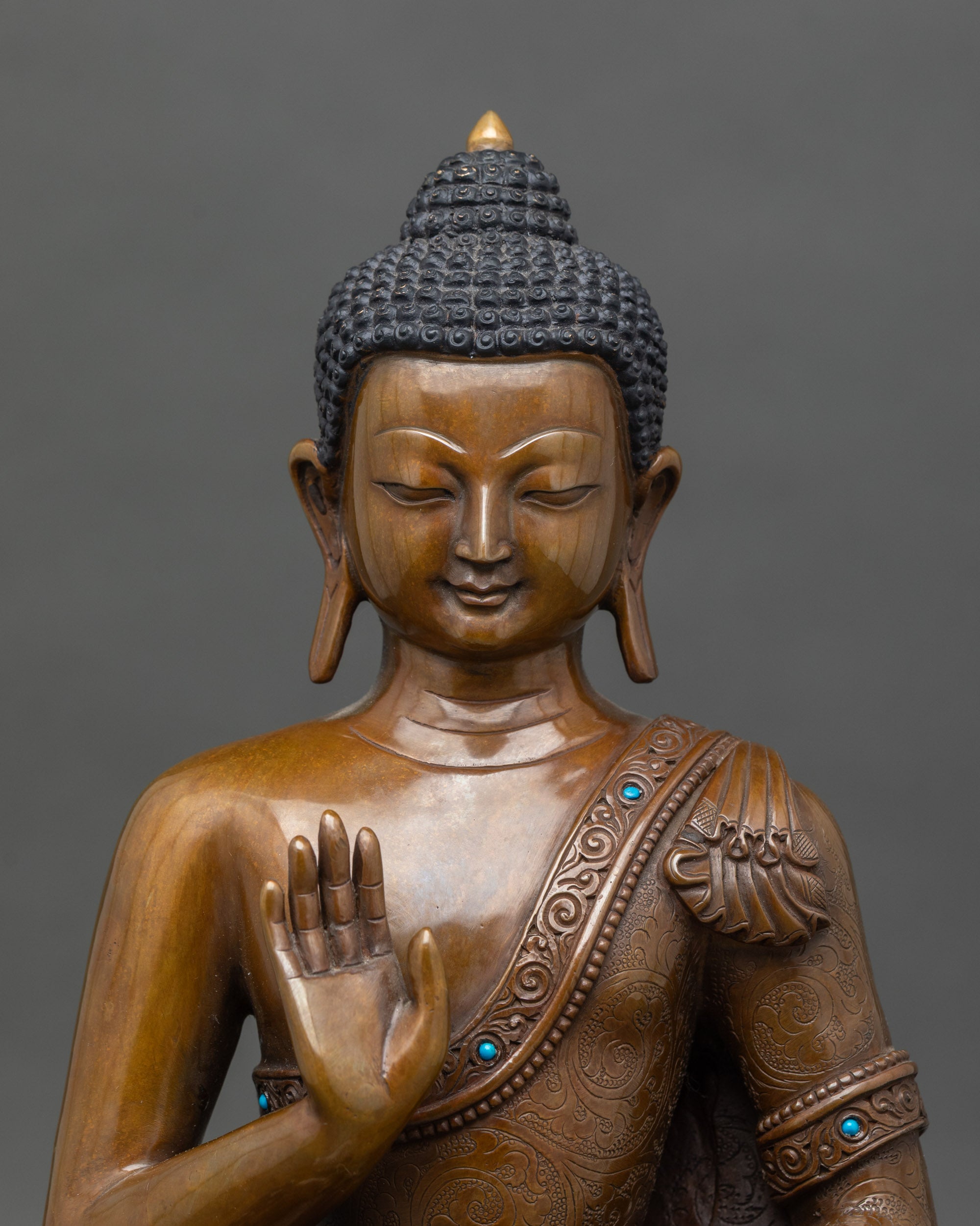 Close-up-Amoghasiddhi-Buddha-face-serene-expression-abhaya-mudra-turquoise-stones-spiritual-statue