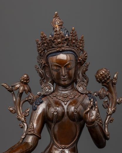 Close up Green Tara face dark oxidized copper with utpala flower and intricate floral motifs