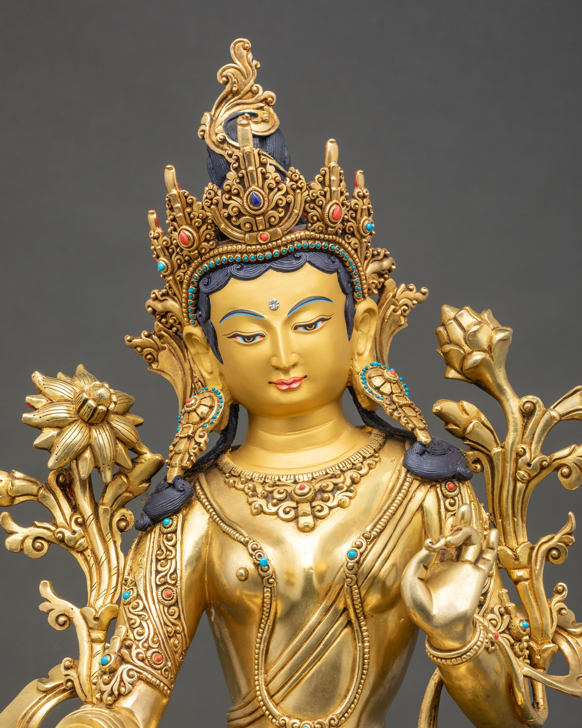 Close-up-Green-Tara-face-serene-expression-gold-painted-crown-semi-precious-stones
