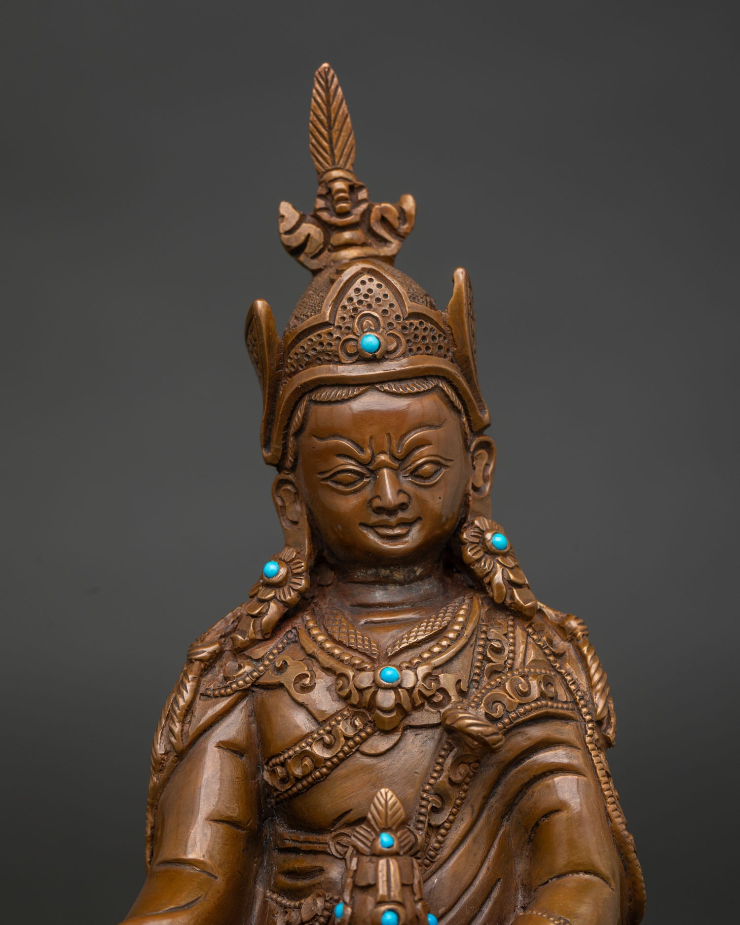 Close up Guru Rinpoche statue showing semi precious stones and detailed royal garments.