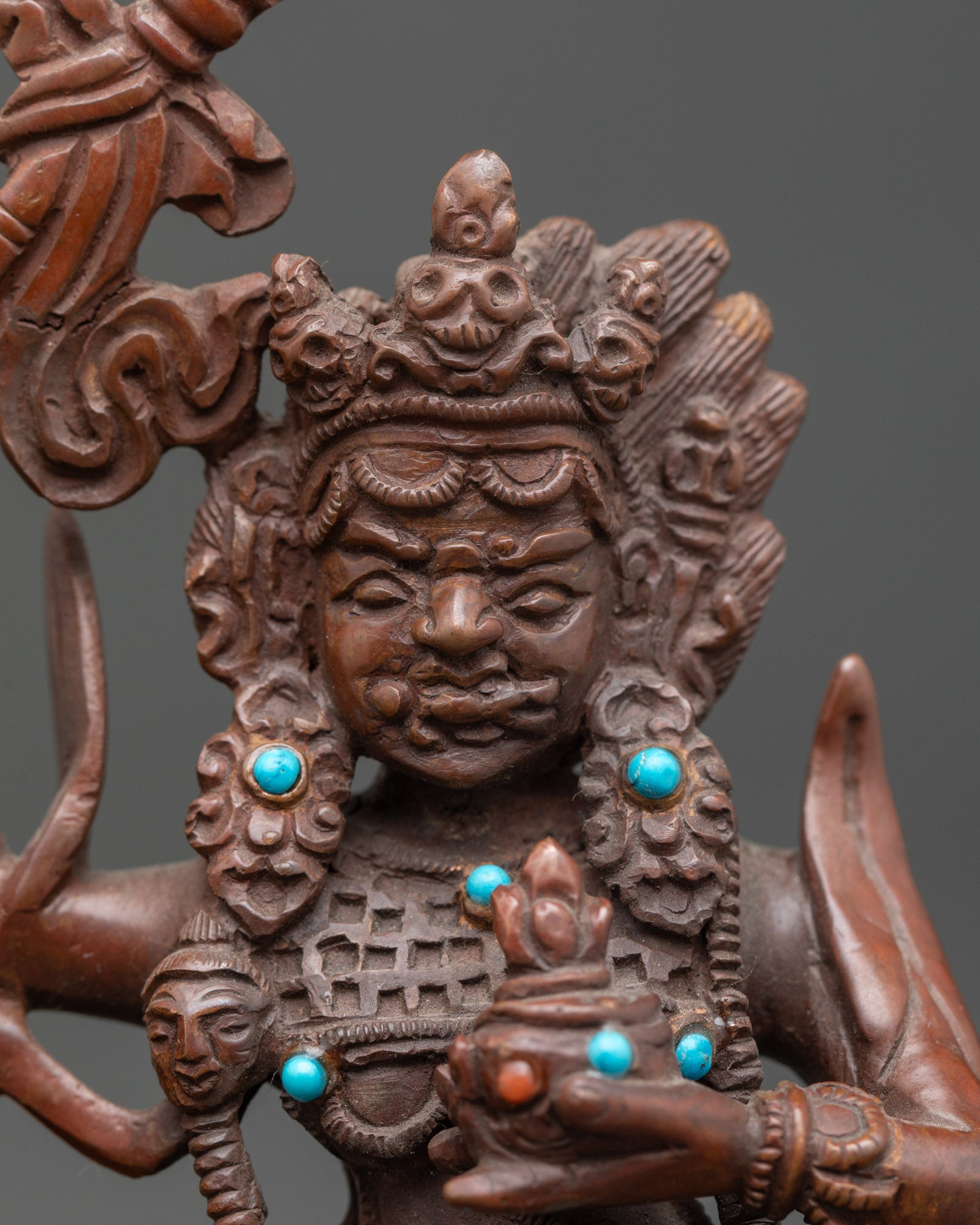 Close up Palden Lhamo face wrathful goddess copper statue with stone inlay detail
