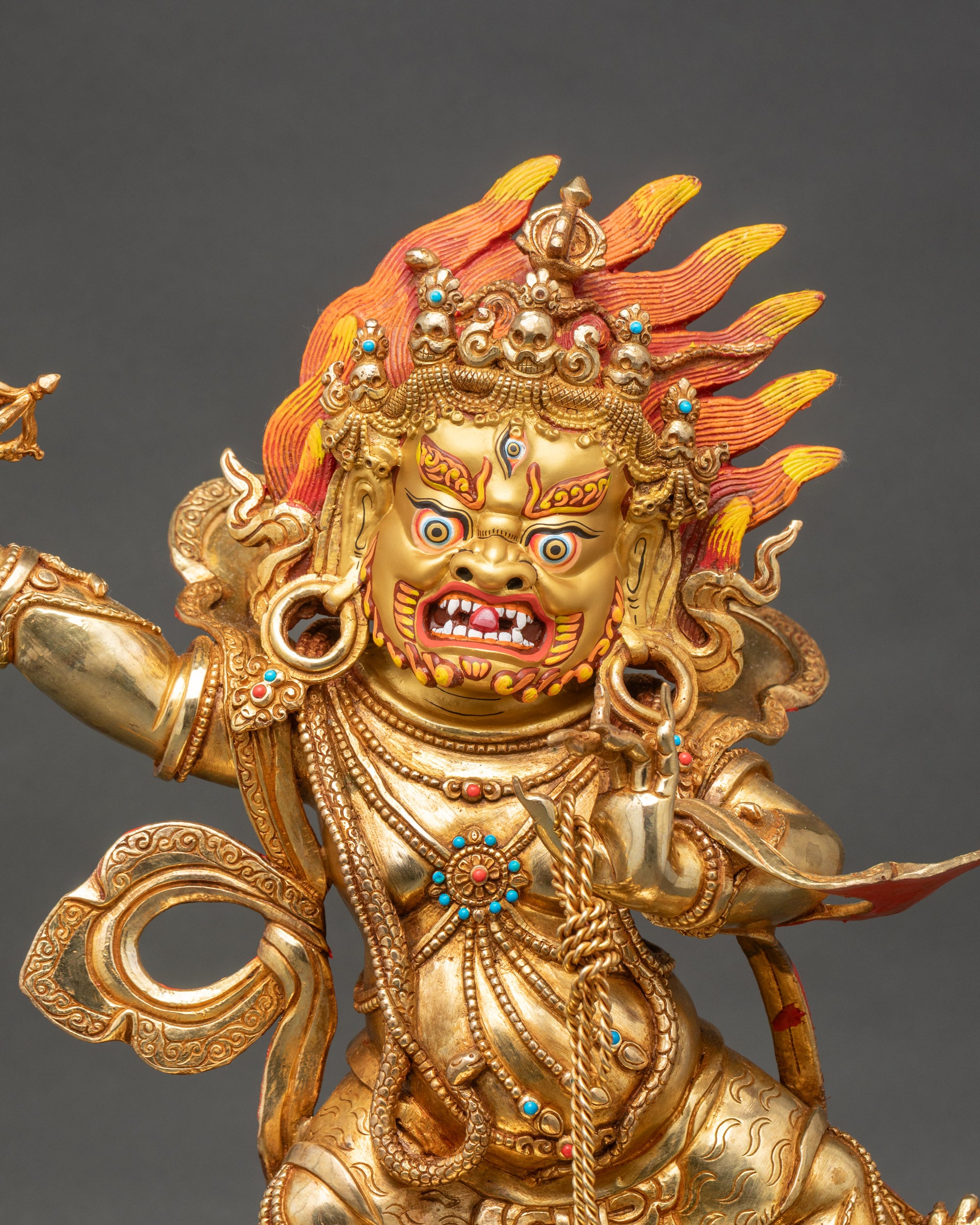 Close-up-Vajrapani-face-expressive-features-gold-painted-copper-semi-precious-stones