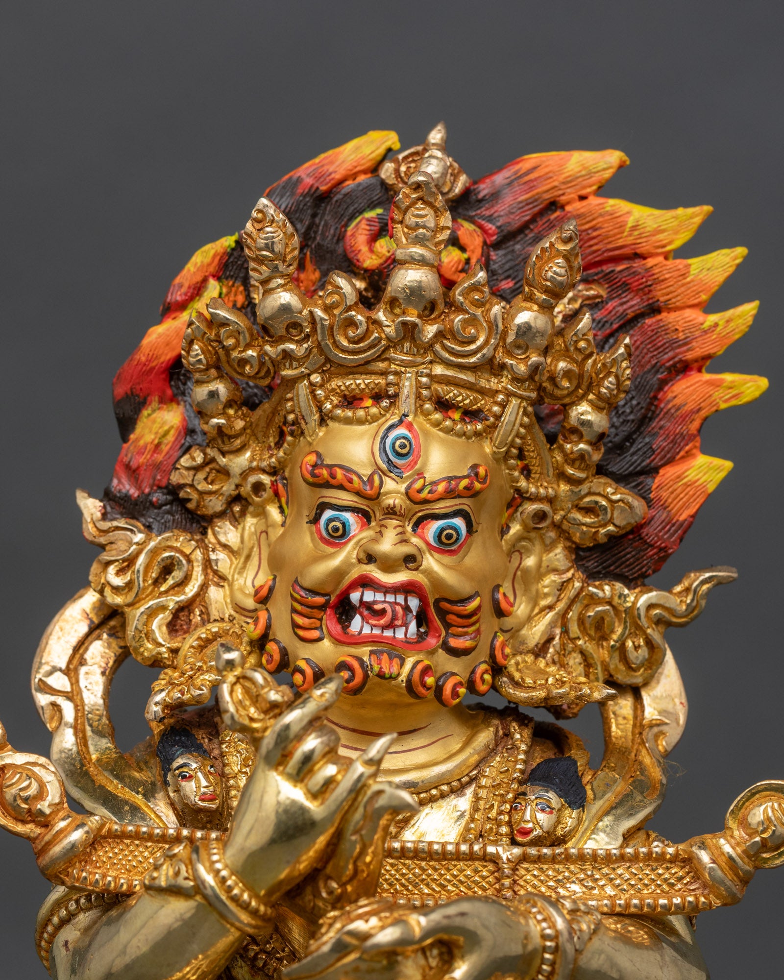 Close up Wrathful Sakya Mahakala face gold painted intricate details Nepalese deity