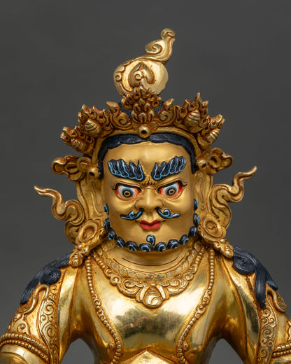 Close up of Dzambhala Statue 24k gold painted face mongoose in hand sacred Nepalese sculpture