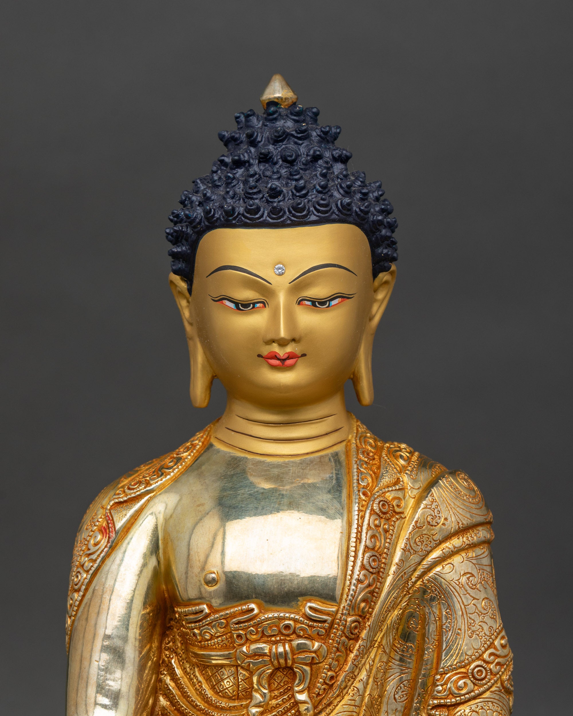 Close-up of Shakyamuni Buddha sculpture showing copper details and gold fire-gilding