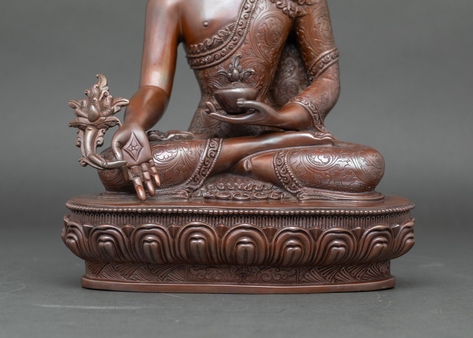 Close-up of Three Buddha statues showing intricate lotus seat and oxidized Newari craftsmanship