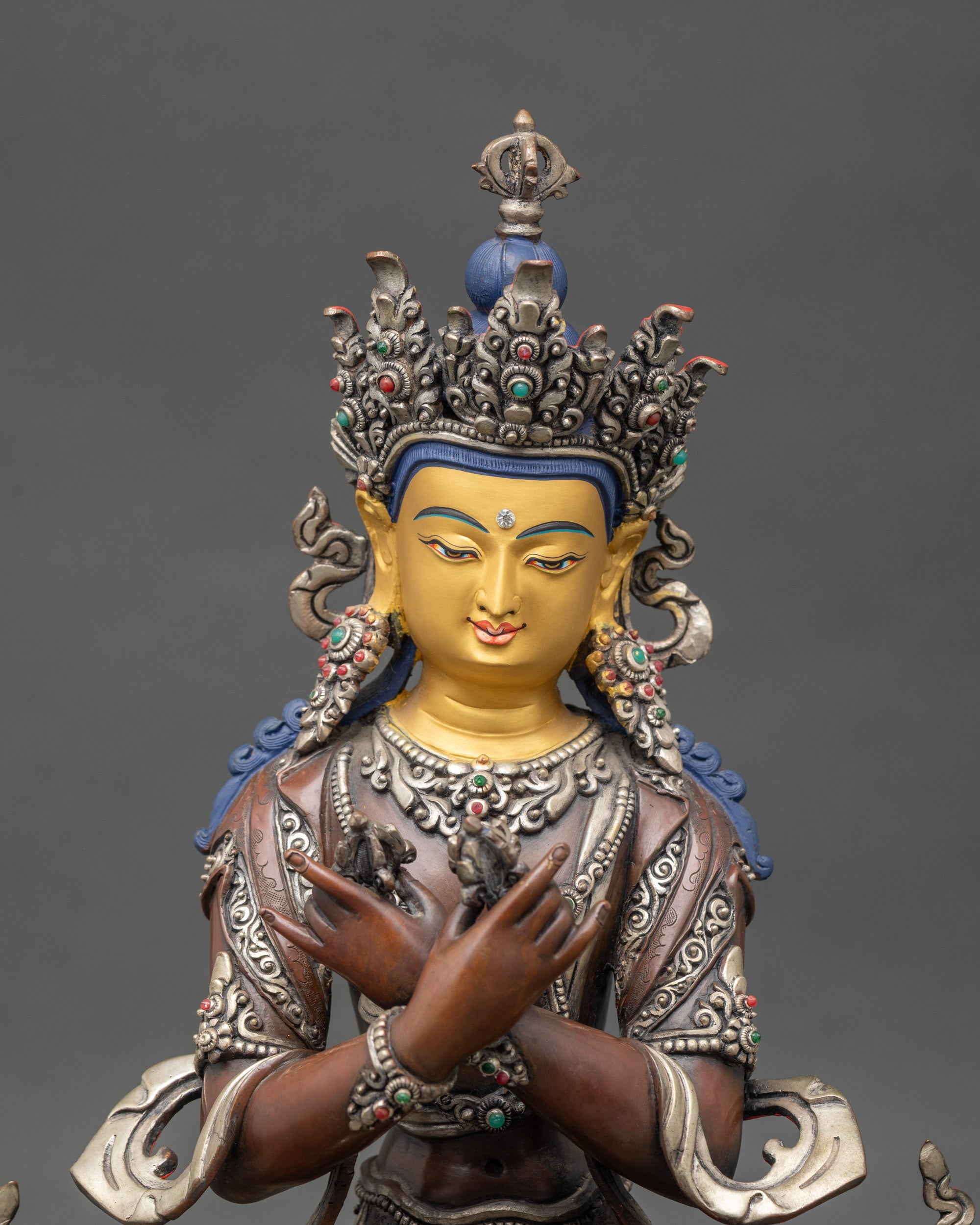Close-up of Vajradhara figurine showing vajra and bell held at heart center