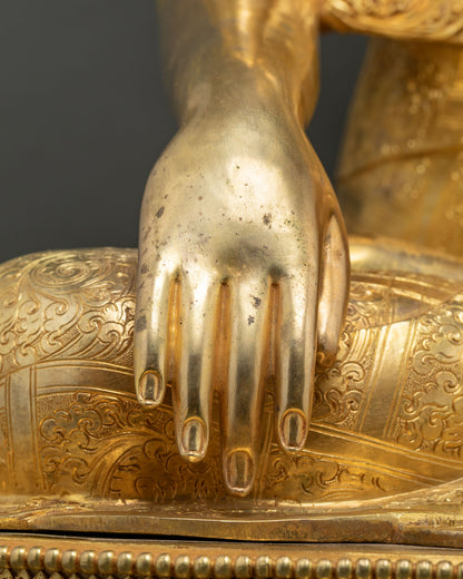 Close-up of Bhumisparsha mudra earth-touching hand gesture on gold Buddha statue