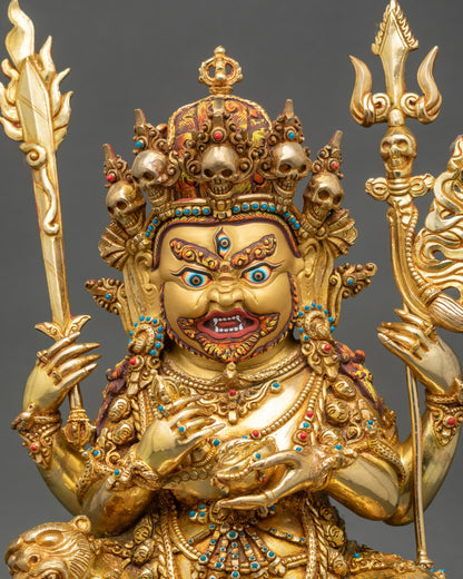 Close-up Chaturbhuja Mahakala sculpture with skull crown and blazing aureole.