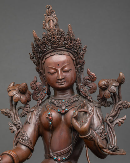 Close-up Green Tara statue | Blue lotus, gold-painted face, and detailed oxidized copper