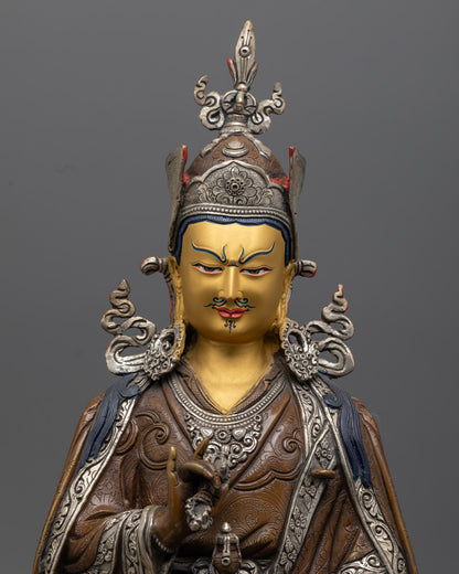 Guru Rinpoche Statue showing intricate details in oxidized copper craftsmanship and facial expressions.