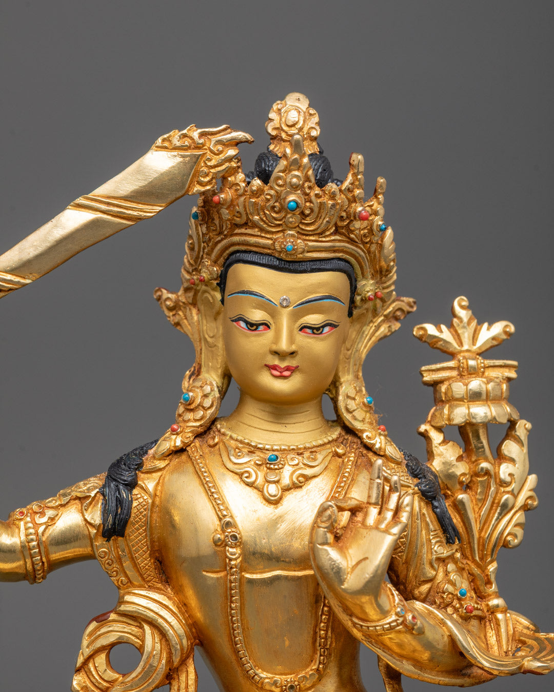 Close-up Manjushri statue showing Abhaya Mudra, utpala flower and gemstone crown