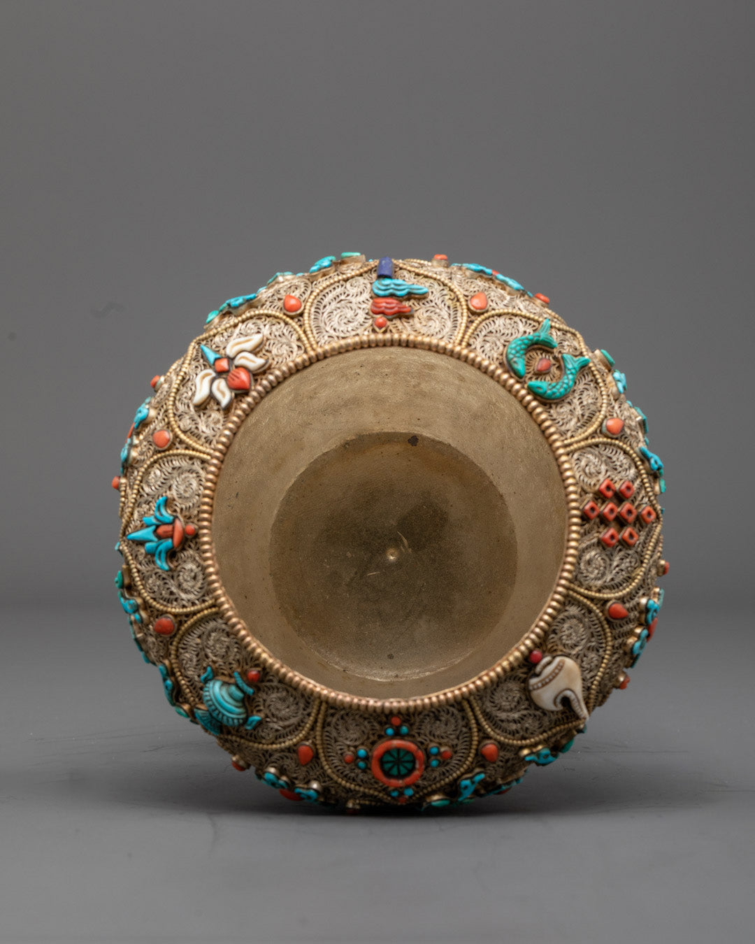 Close-up angled view of sacred Nepali rice bowl's gold filigree