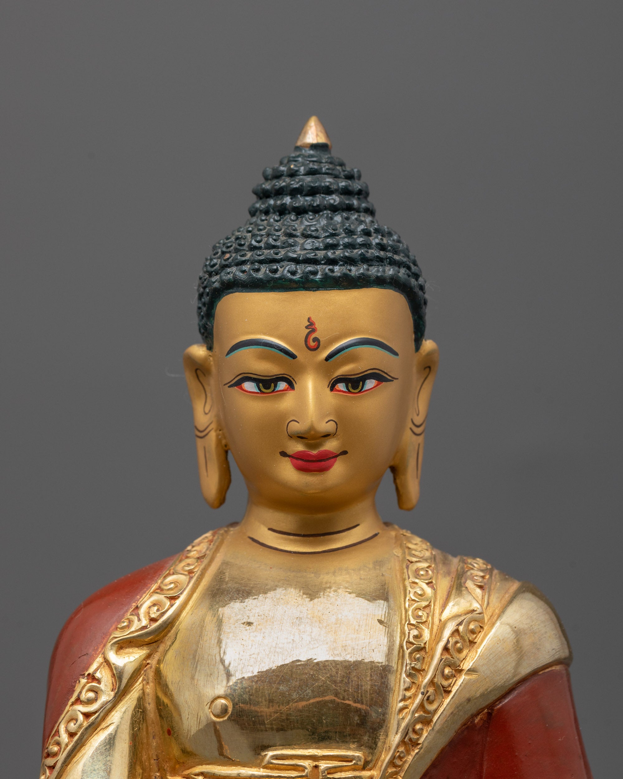 Close-up of 24K gold-gilded face and intricate carvings on Medicine Buddha Statue