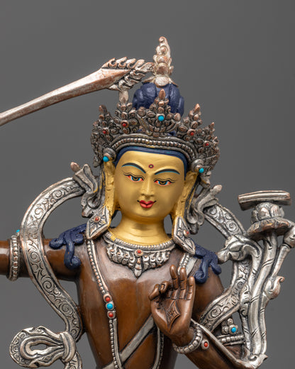 Close-up of 24K gold-gilded face on oxidized Manjushri statue with semi-precious stones