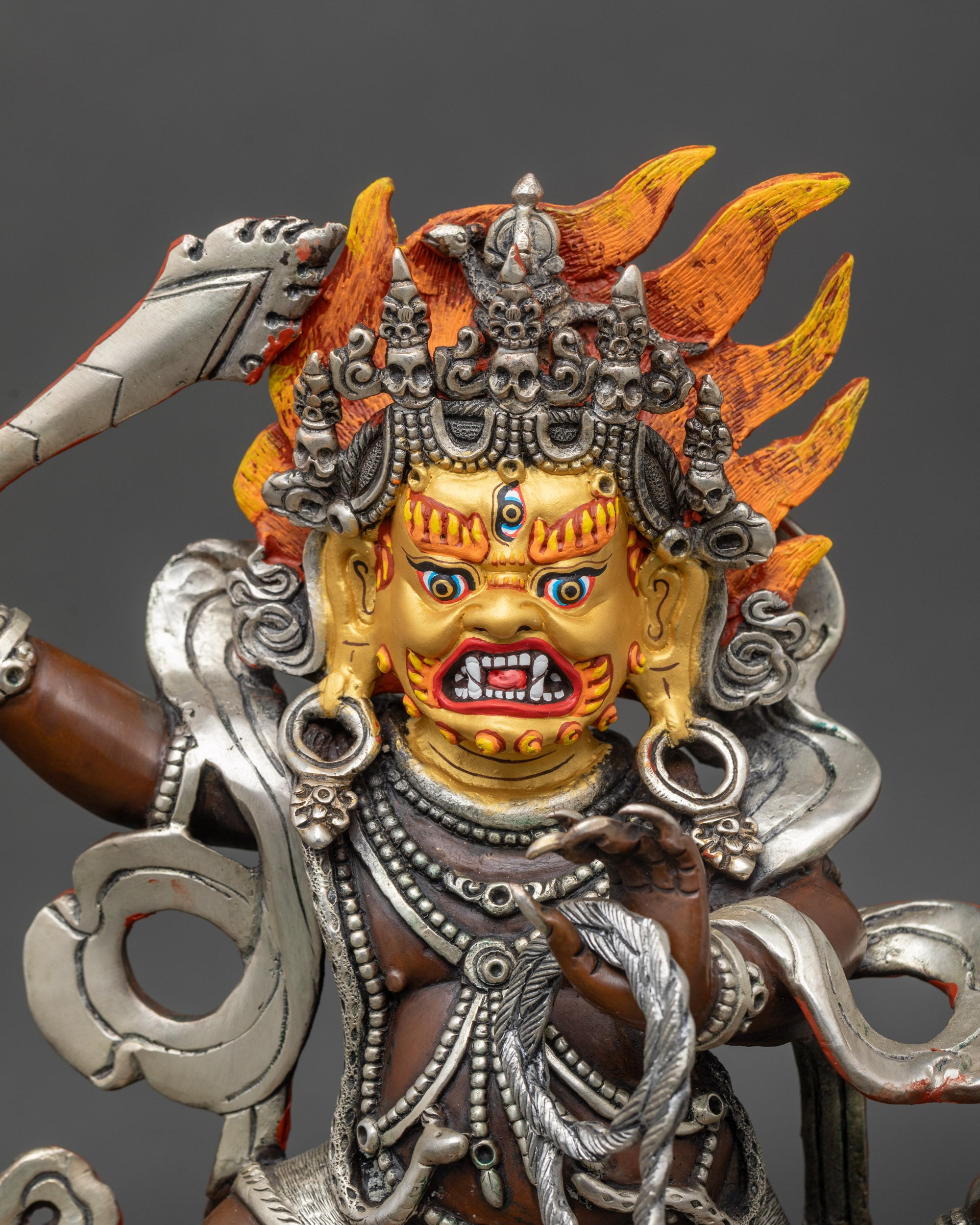 Close-up of Achala statue showing sacred sword, lasso, and coiled serpent, handcrafted Nepalese copper