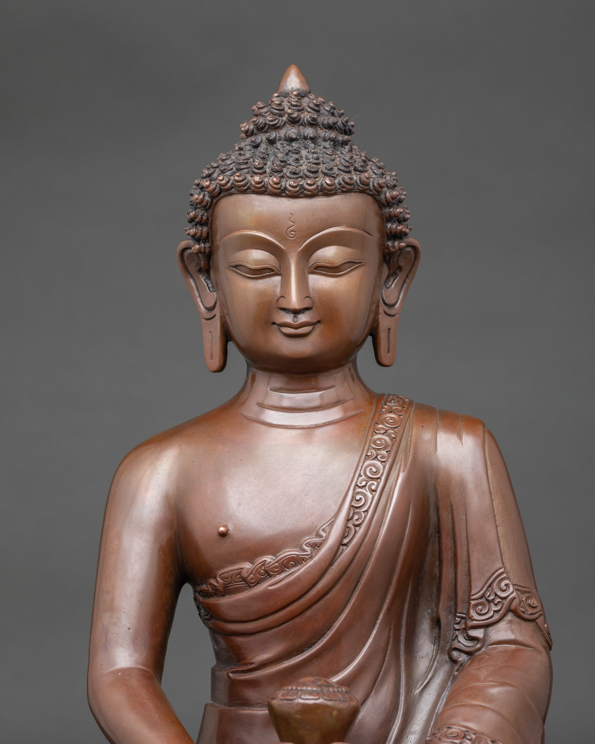 Close-up of Amitabha Buddha face showing serene expression and intricate copper details