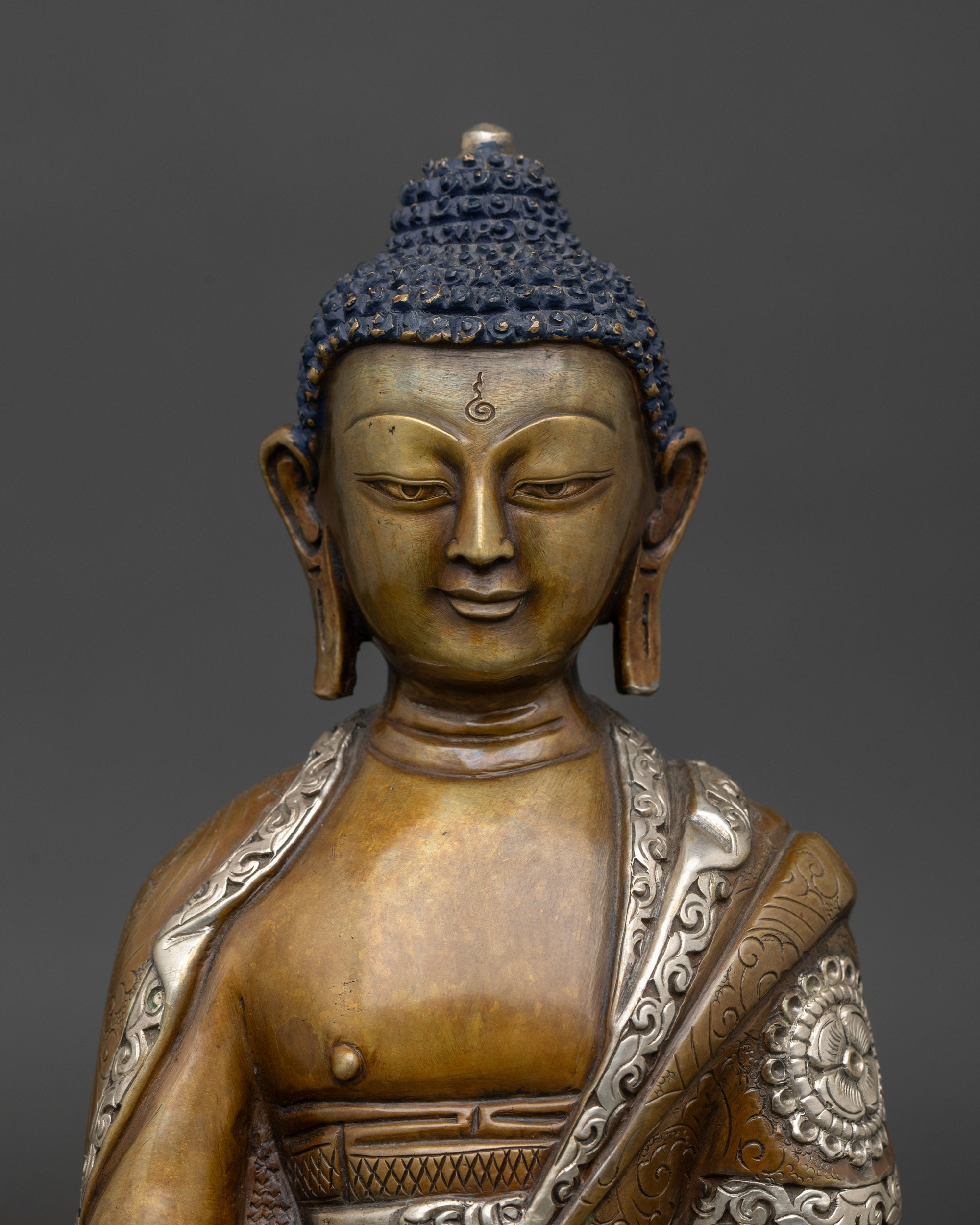 Close-up of Amitabha Buddha statue showing acrylic color detailing and monk’s bowl