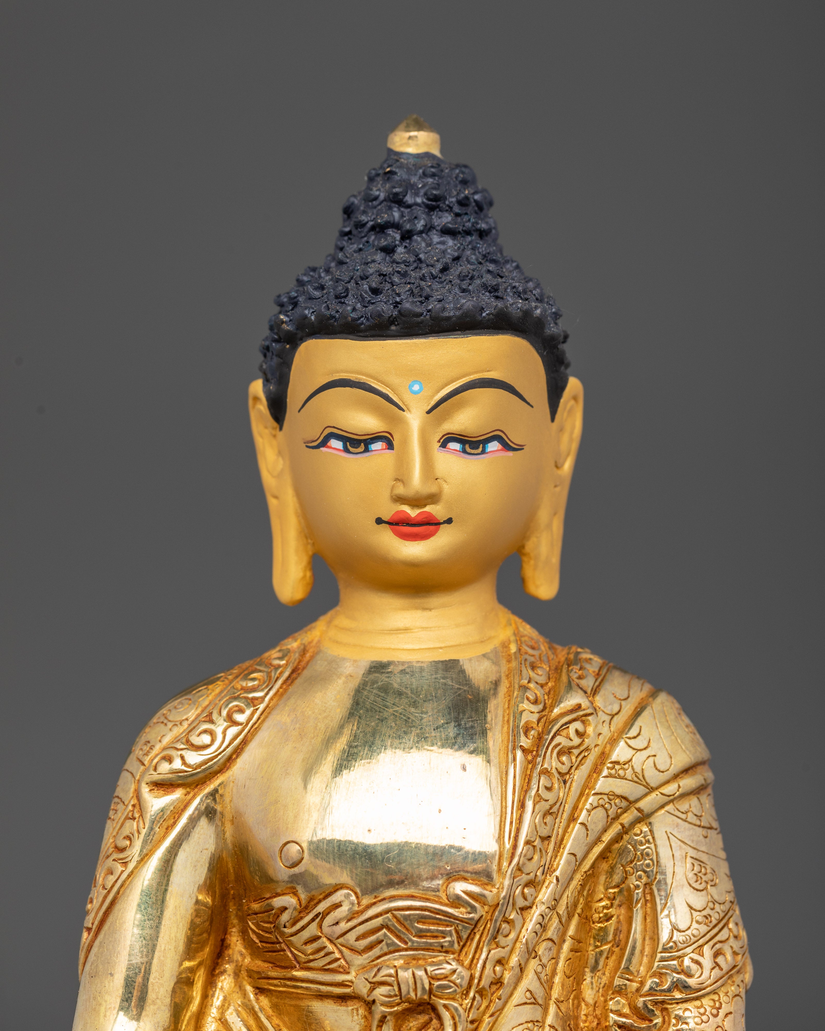 Close-up of Amitabha Buddha statue with 24K gold-painted face holding monk’s bowl