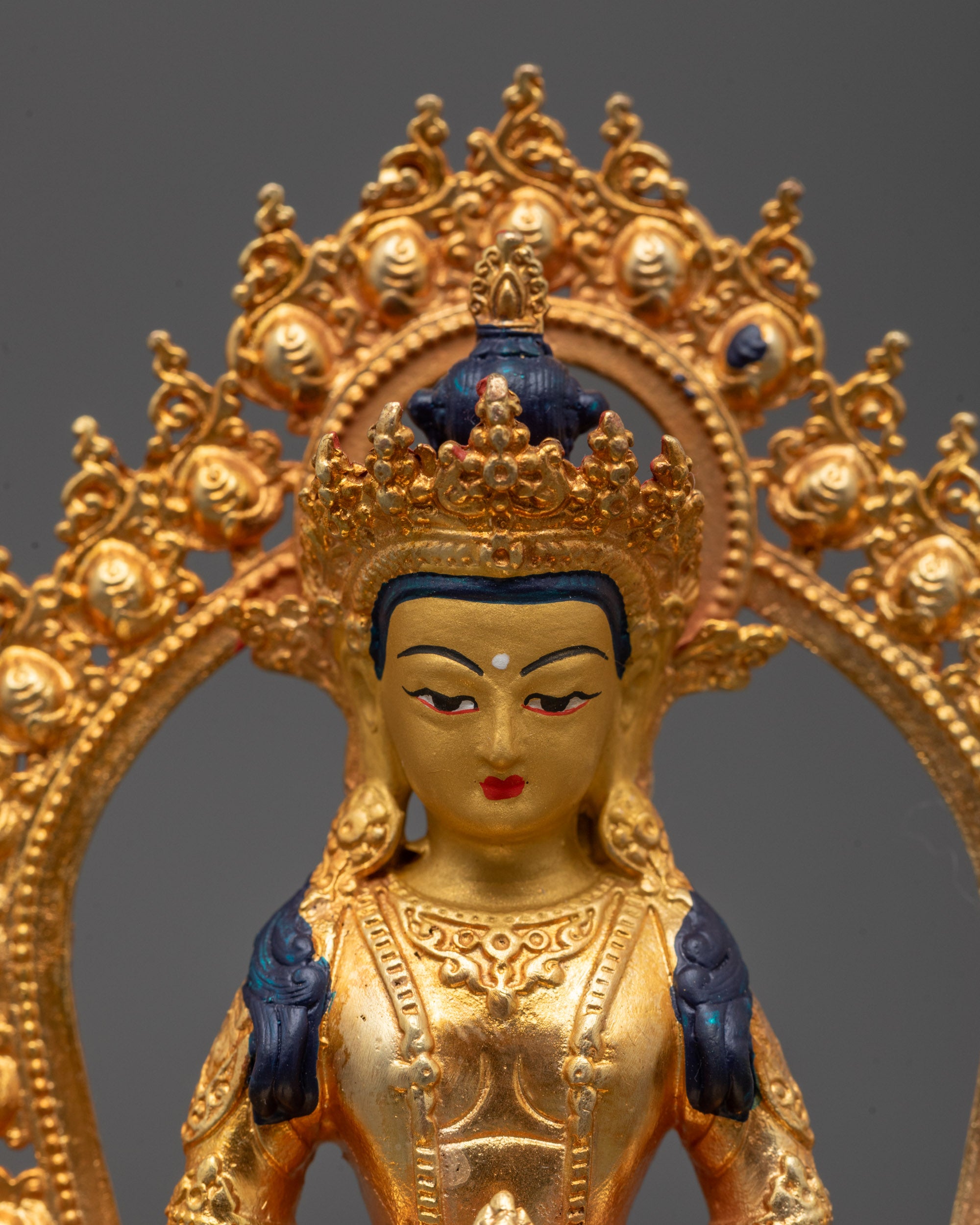 Close-up of Amitayus Buddha’s peaceful expression and radiant gold-coated face