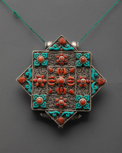 Close-up of Bishwo Vajra Locket showing intricate silver carving and coral double vajra centerpiece
