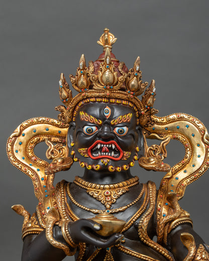 Close-up of Black Dzambhala figure with jewel-spitting mongoose in hand