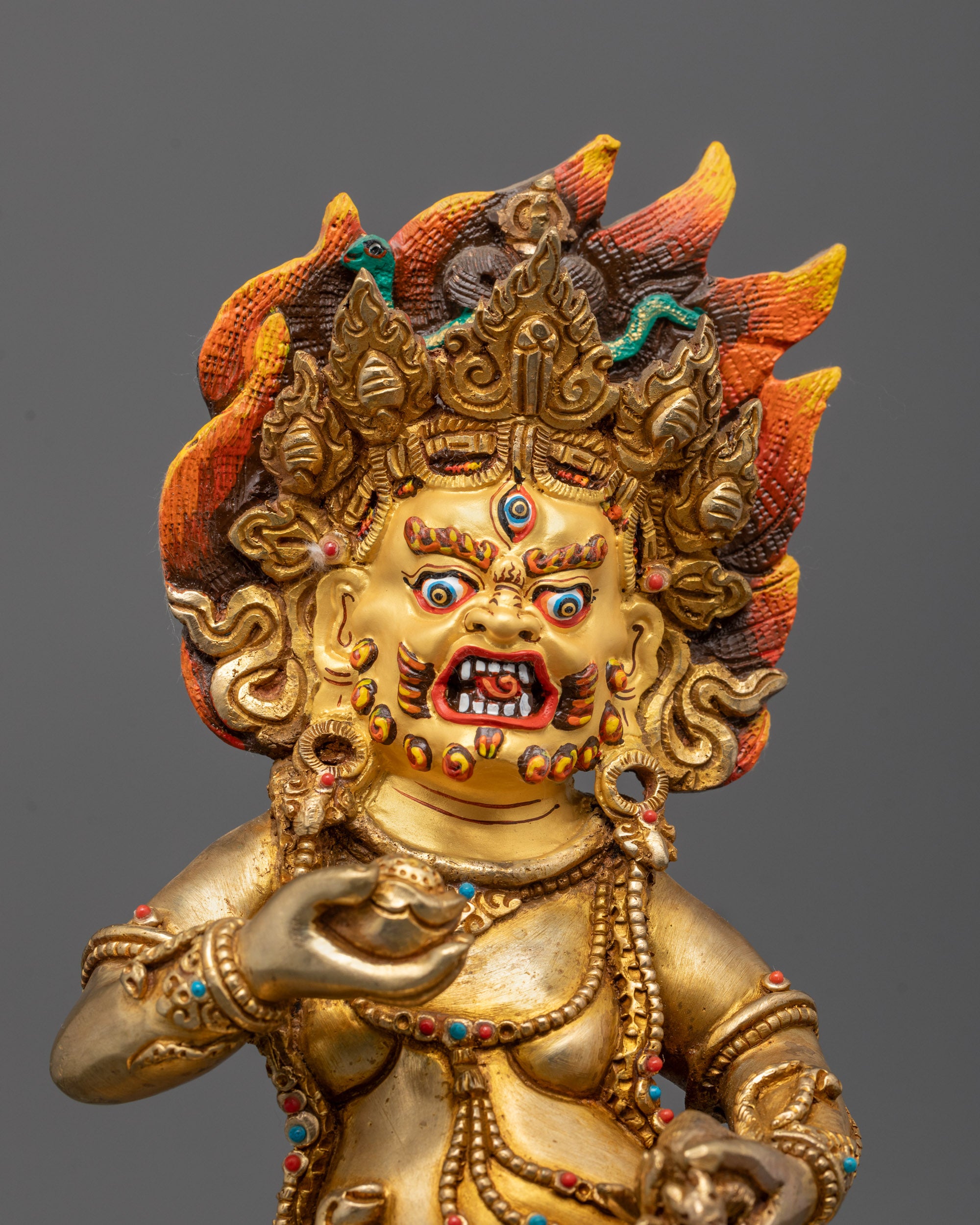 Close-up of Black Dzambhala’s wrathful face and golden crown symbolizing protection wealth