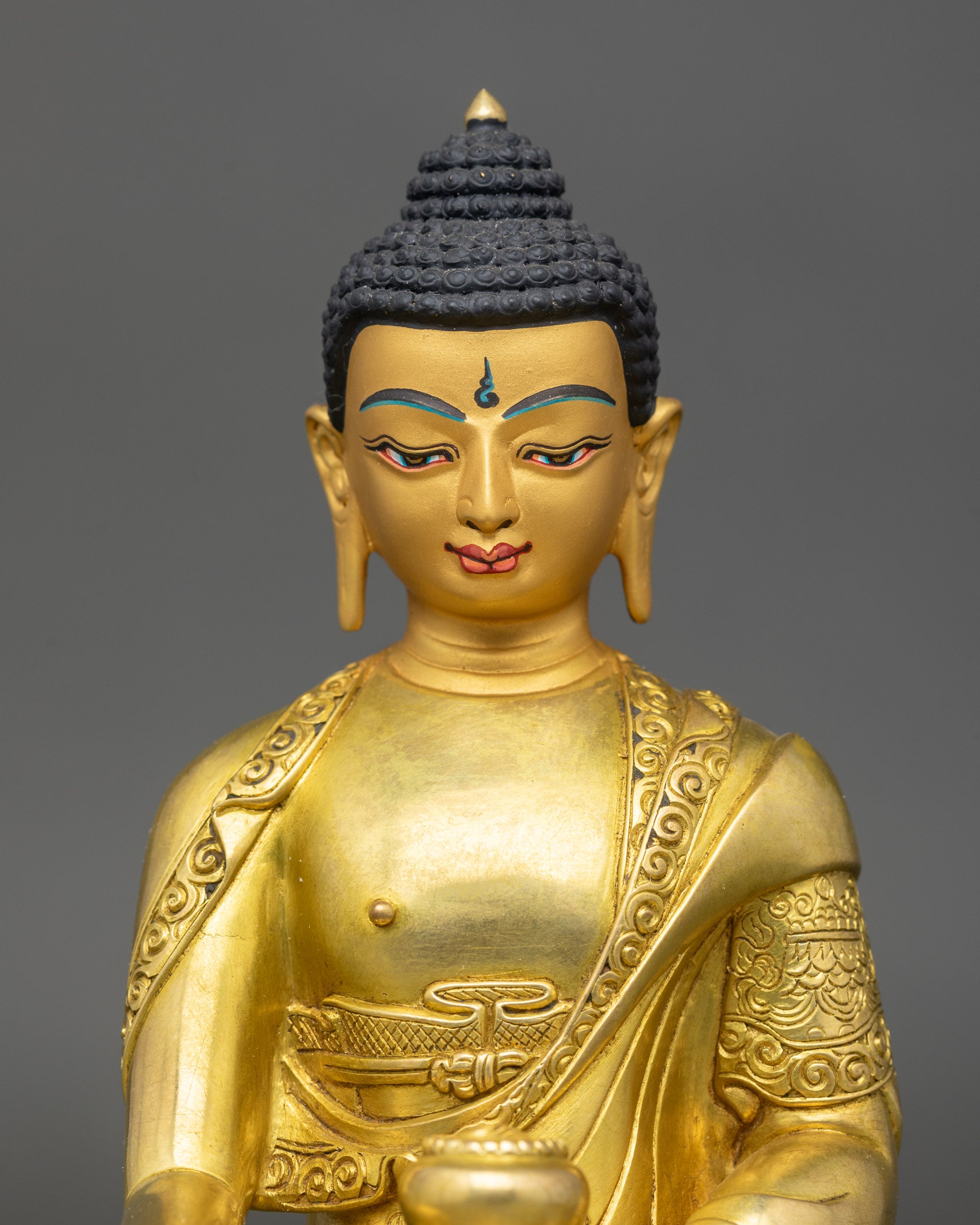 Close-up of Buddha Shakyamuni Statue showing detailed robes and gold-painted face