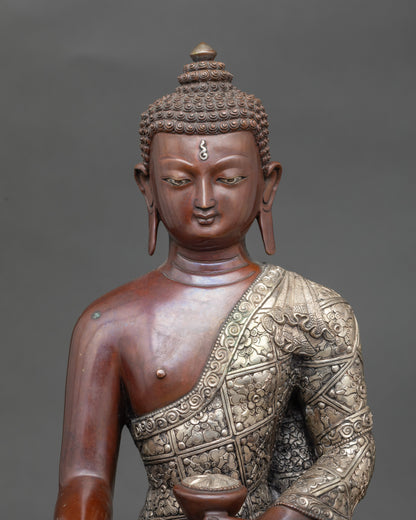Close-up of Buddha Shakyamuni face showing serene expression and silver-plated finish
